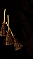Mini witch brooms on black background, occult props, mystical composition, esoteric tools for magic and rituals