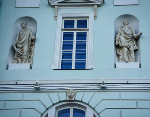A light blue facade of a historic building in St. Petersburg, Russia. A building with two classical statues positioned in niches. for architectural, cultural, or travel-themed content