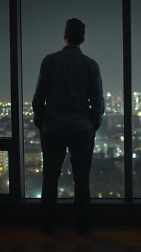 nighttime urban scene with solitude, individual gazes outward as city illuminates surroundings