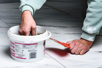 Mixing the fugue in a bucket for grouting ceramic tiles.