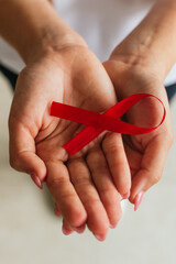 Hands holding red ribbon for World AIDS Day awareness