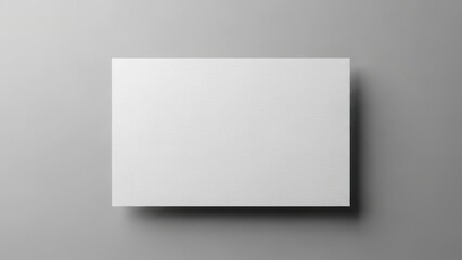 Blank white textured paper casting a shadow on a neutral gray background, copy space for design