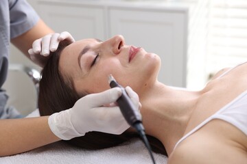 Woman undergoing microneedling procedure in beauty salon, closeup