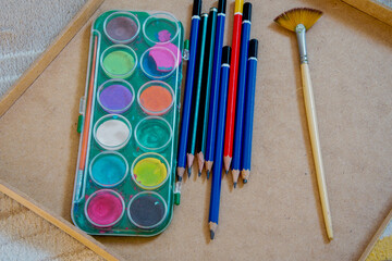 brush kit along with a set of watercolors on a table