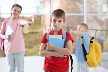 Boy getting bullied by his classmates in school, selective focus
