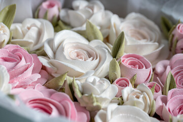 Beautiful arrangement of pink and white roses in a light blue gift box, surrounded by festive decorations, creating a charming holiday atmosphere with soft lighting
