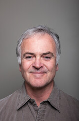 Studio portrait of handsome mature man against grey background.