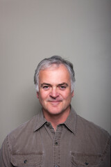Studio portrait of handsome mature man against grey background.