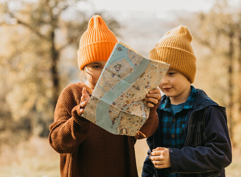Children exploring autumn forest with a map