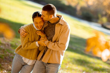 Fototapeta premium Couple enjoying warm moments together in a vibrant autumn park