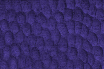 Textured purple wooden surface with carved oval patterns and visible wood grain. Abstract texture...