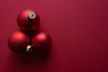 Christmas ornaments pop against a rich crimson background, creating a bold and cohesive visual perfect for advertising campaigns, greeting cards, and festive digital content.