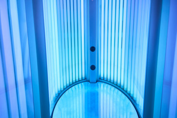 Modern therapeutic tanning setup, Elegant spa environment with ultraviolet illumination, Sophisticated cosmetic treatment station with illuminated UV lamps and sleek equipment