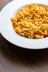 Close-Up of Italian Pasta with Tomatoes and Peppers on a White Plate