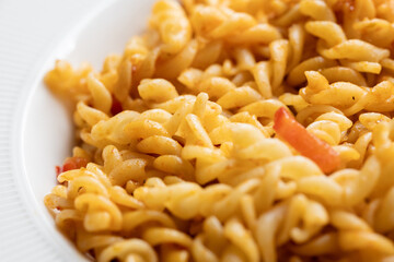 Close-Up of Italian Pasta with Tomatoes and Peppers on a White Plate