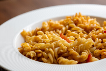 Close-Up of Italian Pasta with Tomatoes and Peppers on a White Plate