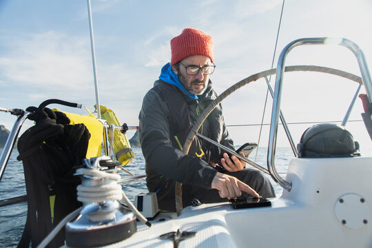 Sailor navigating boat through Norway's scenic fiords