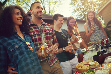 Obraz premium Friends, laugh and beer with party in backyard, bonding and reunion with low angle on weekend. People, group and happy outdoor for drinks, alcohol or lunch at social gathering on holiday in summer
