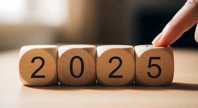 Wooden Blocks Displaying the Year 2025 with a Finger Pressing the Last Block.