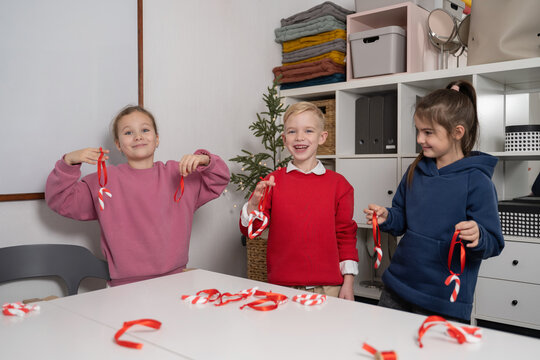 Children crafting Christmas tree decorations together