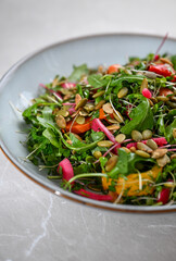 Close up of Arugula, Broccoli Sprouts, Roasted Peppers, Fresh Herbs, and Pumpkin Seeds Salad