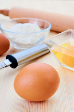 Baking essentials with eggs and flour on wooden table