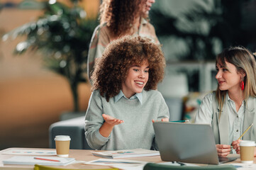 Diverse women collaborating on project during office meeting