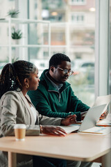 Black business colleagues collaborating on project in office