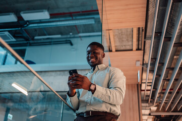 Smiling african american man using smartphone in office