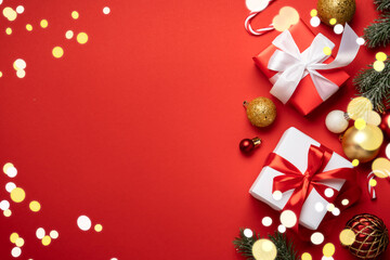 Red and white Christmas decorations and gifts on red background.