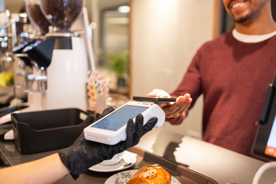 Cafe worker processing payment with POS system