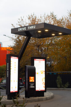 Tbilisi, Georgia - December 04, 2025: Vertical photo. Order registration counter of fast food cafe Wendy's. Counter with car icon and text Order here, Drive thru. Large monitor with advertising, menu