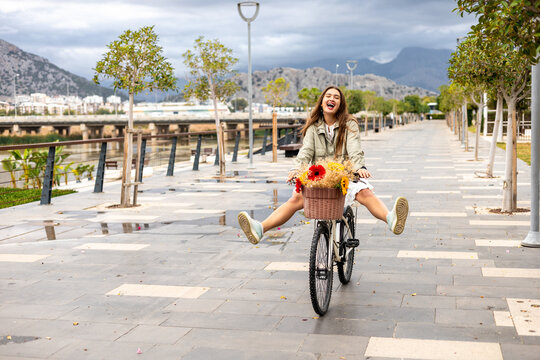 Woman joyfully cycling through scenic park path