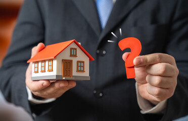 A house and a question mark held by a man in a suit. FAQ on buying and renting a house. Tenant rights. Real estate consulting and support. Housing guides, legal advice and property market.