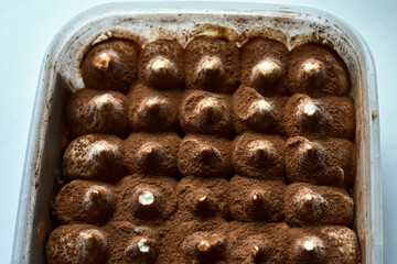 Italian dessert cake Tiramisu. Frozen Tiramisu, ice cream. on plastic package. Piece of cake Tiramisu. Food background.