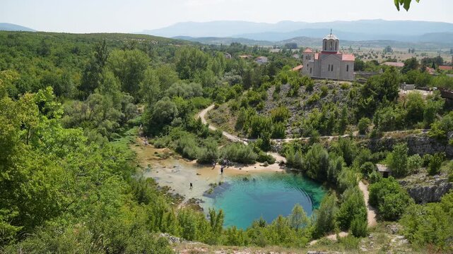 Beautiful landscape of the Cetina River Spring known as the Eye of the Earth with the historic Church of Holy Salvation on a hill in Croatia. 