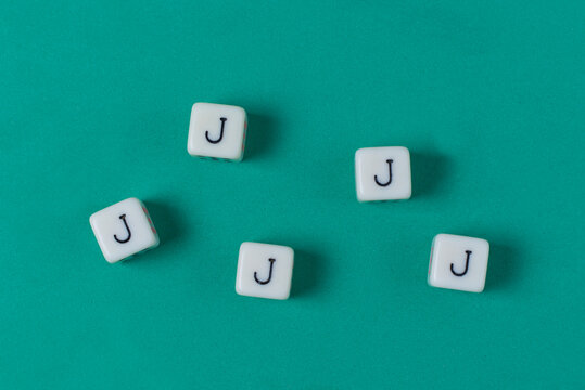 Cinco dados de poker formando un repoker de jotas, sobre fondo verde