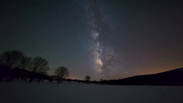 The awe-inspiring Milky Way galaxy stretches across the night sky, illuminating the landscape below. The scene is both beautiful and humbling Stock Video