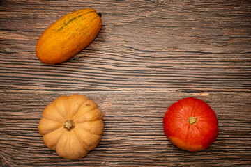 Top view of hokkaido, butternut and nutmeg pumpkins arranged on a dark wooden background. Harvest season