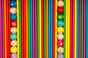 Top view of colorful wooden sticks with two vertical rows of painted beads forming a border frame