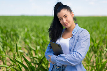 Woman agronomist holding tablet researching corn field
