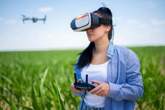 Woman wearing vr headset controlling drone in field