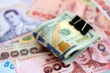Thai baht currency money bills and bunch of us dollar banknotes close up. The concept of economics and currency exchange