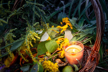 Warm glow enhances peaceful evening, Rustic scene illuminated by gentle amber flames atmosphere, Basket with candles and flowers creates calming seasonal setting