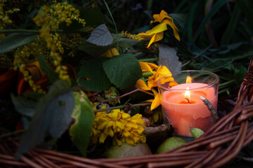 Warm glow enhances peaceful evening, Rustic scene illuminated by gentle amber flames atmosphere, Basket with candles and flowers creates calming seasonal setting