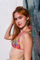 Fototapeta premium Close-up of woman leaning against wall in floral bikini top