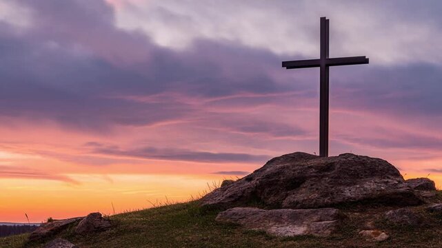 A silhouette of a cross atop a hill at sunset, conveying faith and hope. The cross stands out against the colorful sky, evoking a sense of peace and spirituality. Stock Video