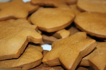 Cookies shaped like stars and circles on a table ready for decoration during a holiday baking session
