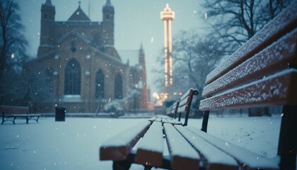 Long wooden park bench covered in snow creates a leading line through a quiet city park during a magical winter evening snowfall with glowing lights