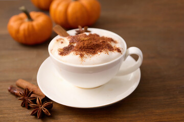 Autumn Latte Delight. A cozy spiced latte with cinnamon on a wooden table